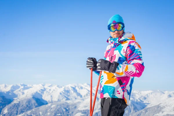 Молодой человек с лыжами и лыжной одеждой — стоковое фото