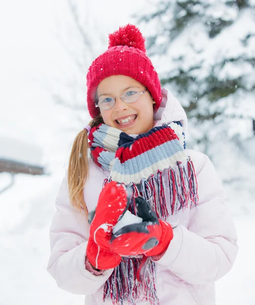 Ευτυχισμένος κορίτσι διασκεδάζοντας στο χιονίζει ημέρα του χειμώνα. — Φωτογραφία Αρχείου
