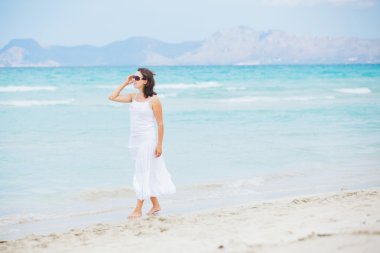 Young woman walking near blue sea.