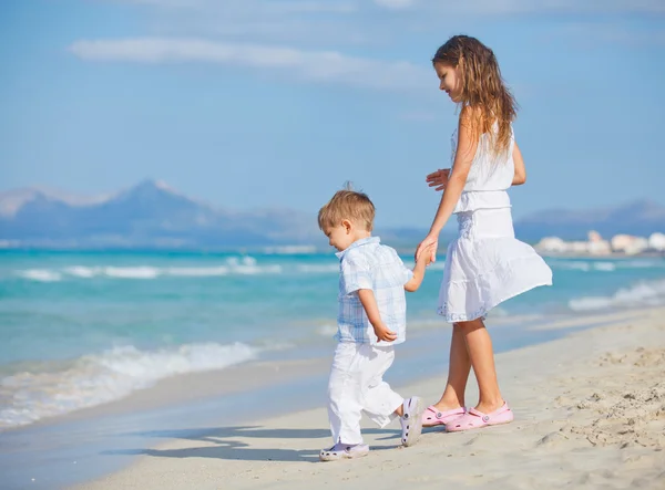 年轻的女孩和男孩在漂亮的海滩上玩得开心 — 图库照片