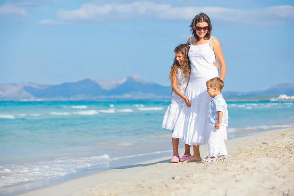 Ung mamma med sina två barn på strandsemester — Stockfoto