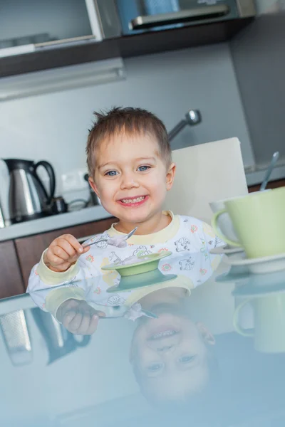 Счастливый мальчик ест завтрак — стоковое фото