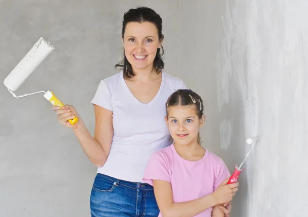 Счастливая мама и дочка покрасили стену — стоковое фото