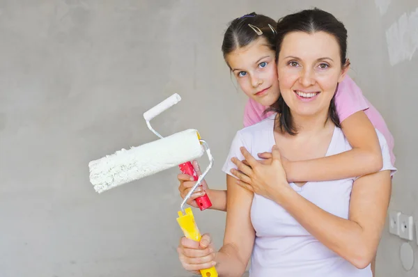 Счастливая мама и дочка покрасили стену — стоковое фото
