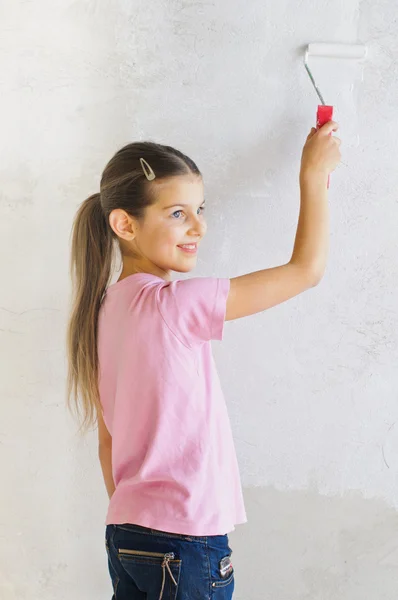 Menina feliz pintando uma parede — Fotografia de Stock
