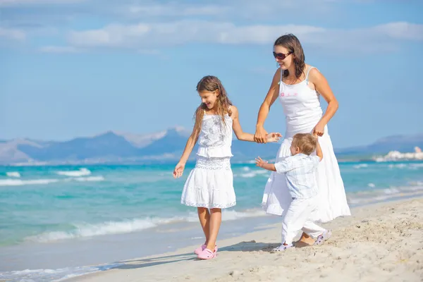 Młode matki z jej dwoje dzieci na wakacje na plaży — Zdjęcie stockowe
