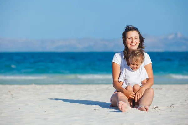 Jovem mãe e seu filho brincando na praia — Fotografia de Stock
