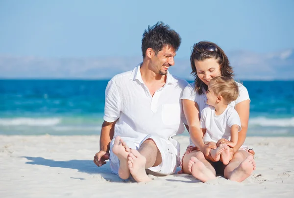 Familjen sitter på tropical beach — Stockfoto