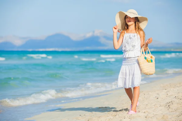 Menina adorável vestindo chapéu elegante na praia — Fotografia de Stock