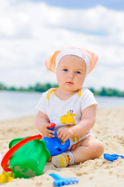 Χαριτωμένο κοριτσάκι, παίζοντας στην παραλία με άμμο. — Φωτογραφία Αρχείου