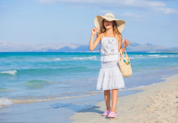 Schattig meisje elegante hoed te dragen op het strand — Stockfoto