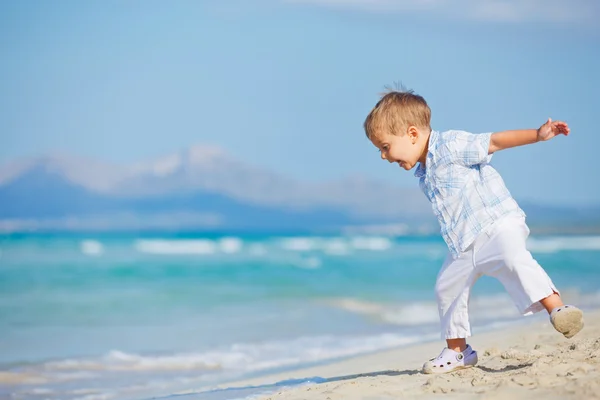 Joven lindo chico jugando felizmente en la playa bonita —  Fotos de Stock