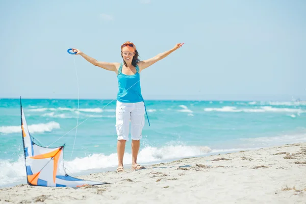 Mujer en la playa jugando con una cometa colorida — Foto de Stock