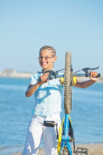 Vacker ung flicka står med sin cykel — Stockfoto