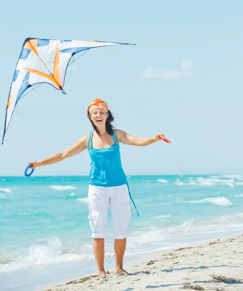 Vrouw op spelen met een kleurrijke kite strand — Stockfoto
