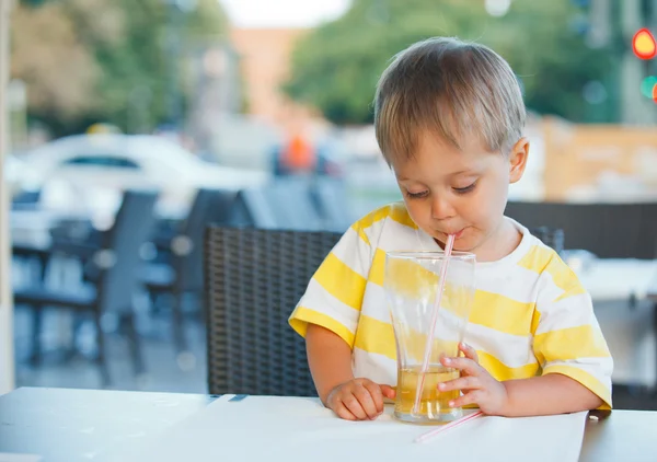Retrato de adorável menino bebendo suco — Fotografia de Stock