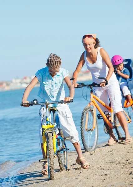 Söt flicka med sin mor och bror rida cyklar — Stockfoto