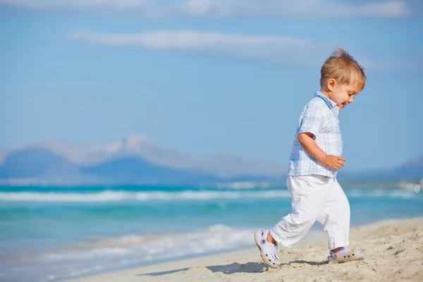 Young cute boy playing happily at pretty beach — Stok fotoğraf