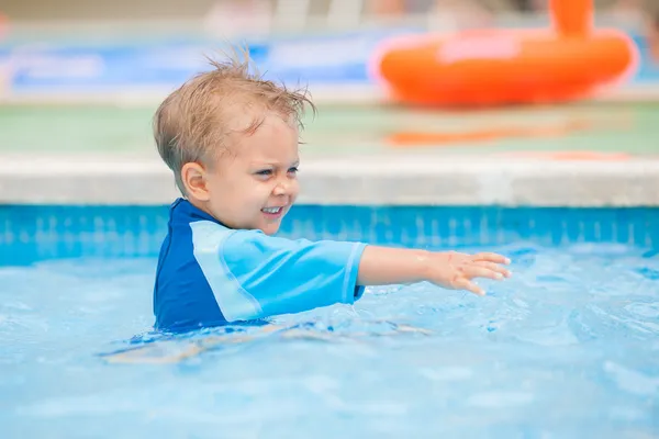 Chlapec hraje v kaluži vody — Stock fotografie