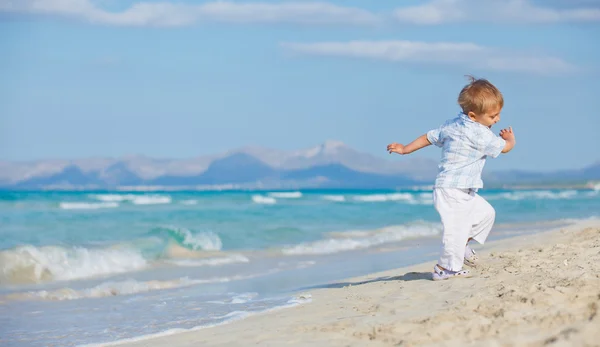 Kleiner süßer Junge spielt fröhlich am schönen Strand — Stockfoto