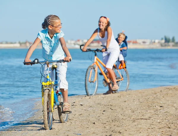 Leuk meisje met haar moeder en broer fietsen rijden — Stockfoto