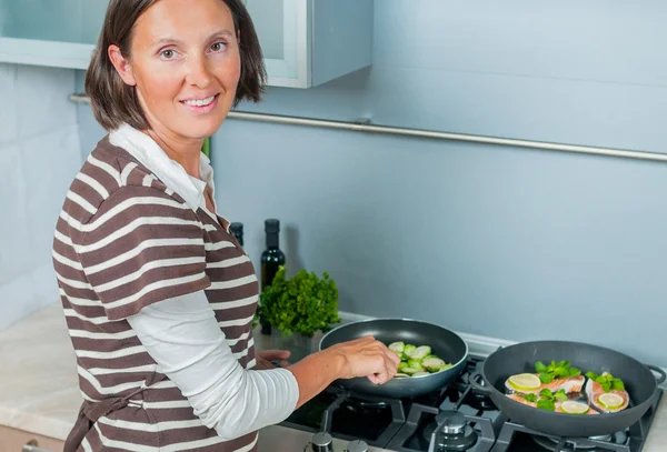 Portrait of a girl looking positive and cooking — Stock Photo, Image