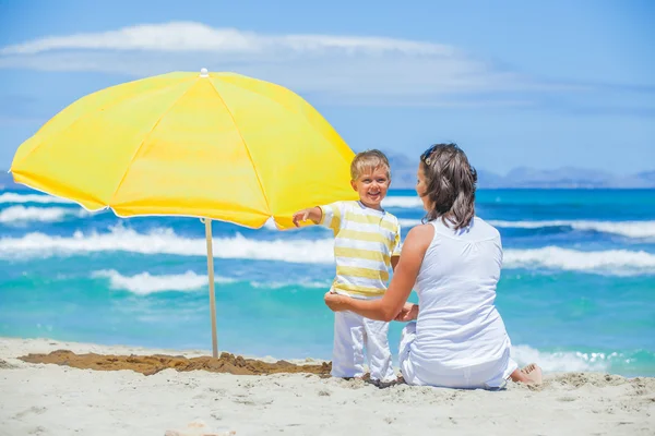 Мальчик и его мать с большим зонтиком — стоковое фото