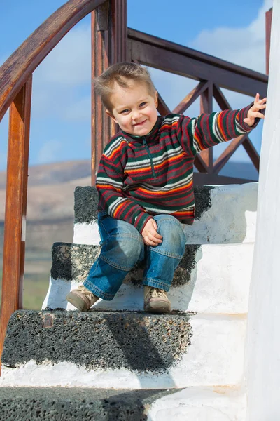 Szczęśliwy chłopiec siedzący na schodach — Zdjęcie stockowe