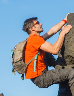 Young man in glasses with backpack climbing clipart