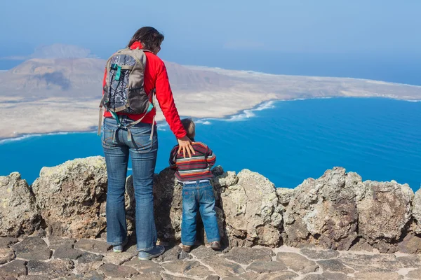 Back view mother and son standing on cliff's edge — Stock Photo, Image