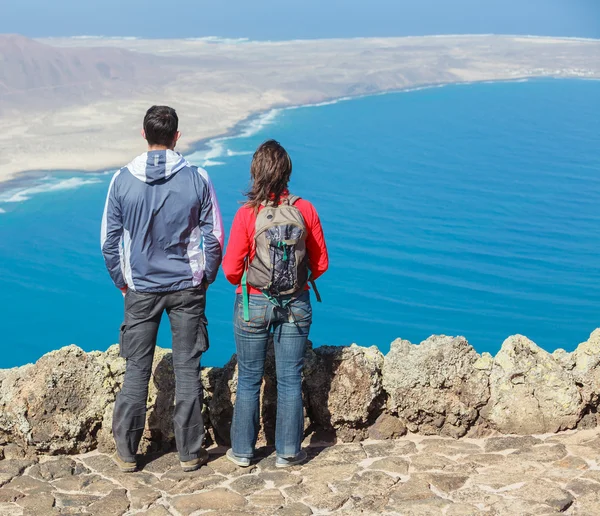 Sport couple standing on cliff's edge — Stock Photo, Image