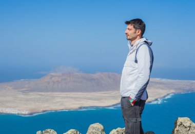 View of man standing on cliff's edge clipart