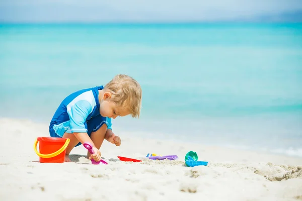 Ragazzo che gioca con i giocattoli sulla spiaggia tropicale — Foto Stock