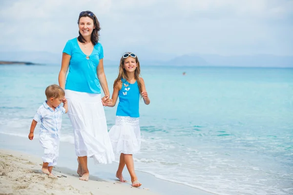 Matka a dvě děti baví na pláži — Stockfoto