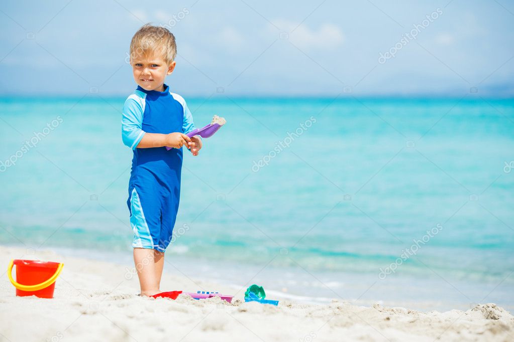 Boy playing with beach toys on tropical beach