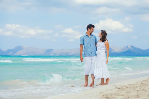 Joyeux jeune couple marchant sur une plage tropicale — Photo