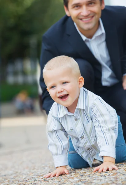 Мальчик, гуляющий в городском парке со своим отцом — стоковое фото