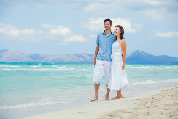 Lyckliga unga paret gå på en tropisk strand — Stockfoto