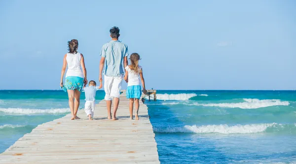 Сім'я з чотирьох на дерев'яній дрібці біля океану — стокове фото
