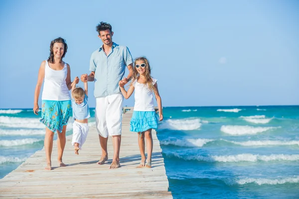 Family of four on jetty by the ocean — Stockfoto