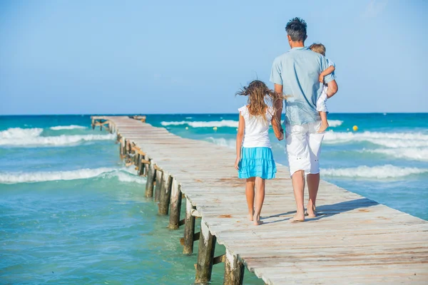 Family of three on jetty by the ocean — Stock Photo, Image