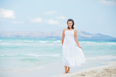 Young woman walking near blue sea.