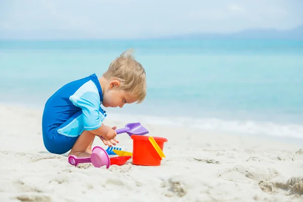 Boy playing with beach toys on tropical beach — Stock Photo, Image