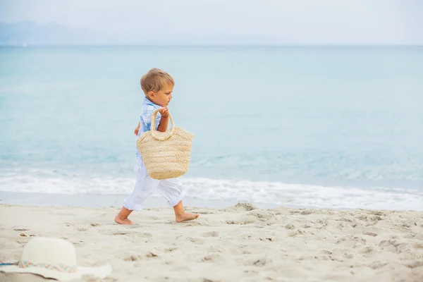 Niño con bolsa de playa en la playa tropical — Foto de Stock