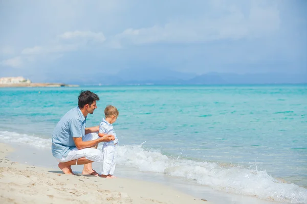 Pai feliz e seu filho brincando na praia — Fotografia de Stock