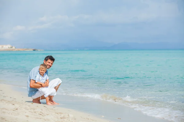 Glücklicher Vater und sein Sohn spielen am Strand — Stockfoto
