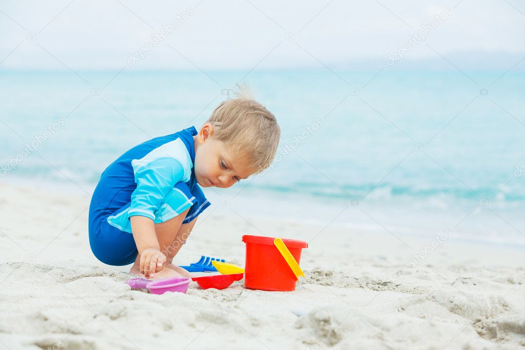Boy playing with beach toys on tropical beach