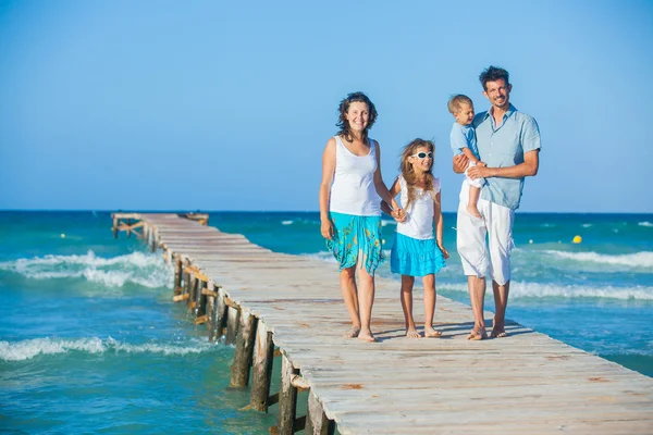 Family of four on jetty by the ocean — Stock Photo, Image
