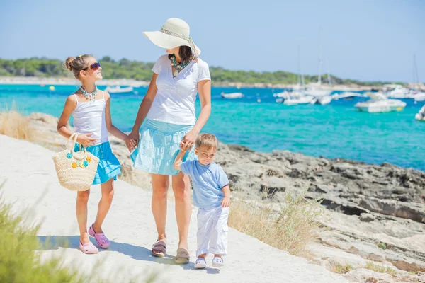 Família de três caminhadas ao longo da praia tropical — Fotografia de Stock
