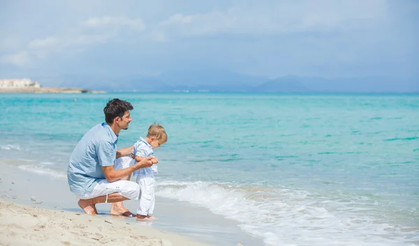 Mutlu baba ve oğlu kumsalda oynarken — Stok fotoğraf